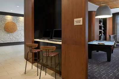 a office with a desk with a pool table and stools at Courtyard by Marriott Calgary Airport in Calgary