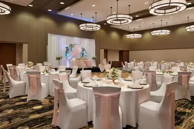 a banquet hall with white tables and white chairs at Courtyard by Marriott Calgary Airport in Calgary