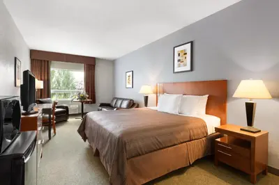 a hotel room with a bed and a television at High Prairie Inn in High Prairie
