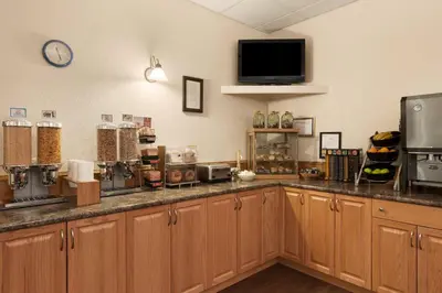 a kitchen with wooden cabinets and a tv on the wall at High Prairie Inn in High Prairie