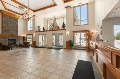 a large living room with a fireplace and windows at High Prairie Inn in High Prairie