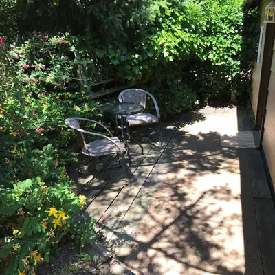 a table and a chair sitting on a patio at Driftwood Village Cottages in Sturdies Bay