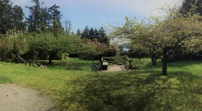 a park with a picnic table in the grass at Driftwood Village Cottages in Sturdies Bay