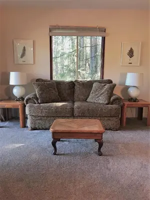 a living room with a couch and a coffee table at Driftwood Village Cottages in Sturdies Bay