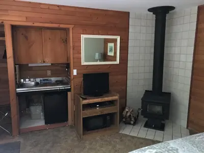 a kitchen with a stove and a tv in a room at Driftwood Village Cottages in Sturdies Bay