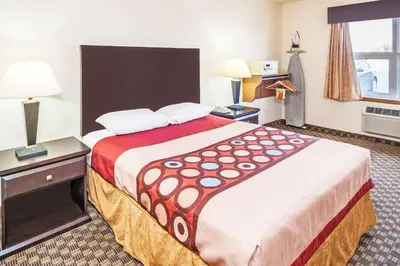 a hotel room with a large bed and a window at Super 8 by Wyndham Calgary/Airport in Calgary