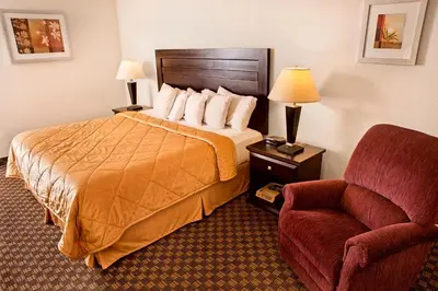 a hotel room with a bed and a chair at Super 8 by Wyndham Calgary/Airport in Calgary