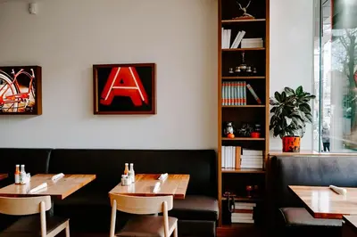 a restaurant with two tables and a sign on the wall at Blue Horizon Hotel in Vancouver