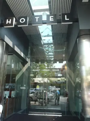 a glass entrance to a building with a sign on it at Blue Horizon Hotel in Vancouver