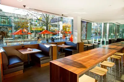 a restaurant with a long table and chairs at Blue Horizon Hotel in Vancouver