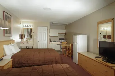 a hotel room with a bed and a kitchen at Canadas Best Value Inn and Suites Fernie in Fernie