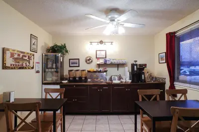 a kitchen with a table and a ceiling fan at Canadas Best Value Inn and Suites Fernie in Fernie