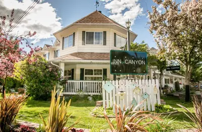 a house with a sign in front of it at Inn on Canyon in Radium Hot Springs