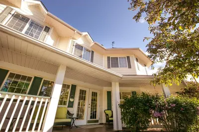 a large white house with a front porch at Inn on Canyon in Radium Hot Springs