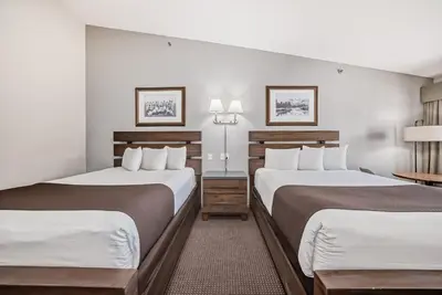 a hotel room with two beds and two lamps at Canmore Rocky Mountain Inn in Canmore