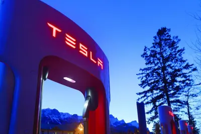 a tesla gas station with a tree in the background at Canmore Rocky Mountain Inn in Canmore