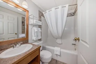 a bathroom with a sink and a toilet and a mirror at Canmore Rocky Mountain Inn in Canmore