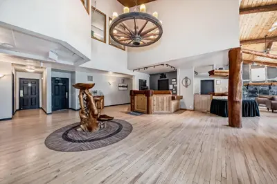 a large room with a wooden floor and a chandelier at Canmore Rocky Mountain Inn in Canmore