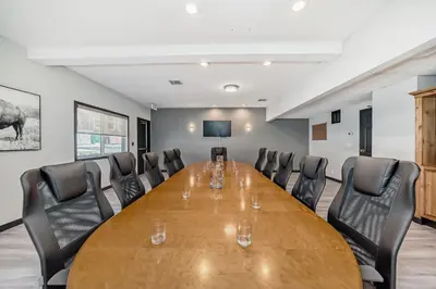 a conference room with a wooden table and chairs at Canmore Rocky Mountain Inn in Canmore