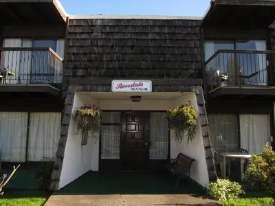 a building with a sign that reads anchorage village at Rosedale Manor in Duncan