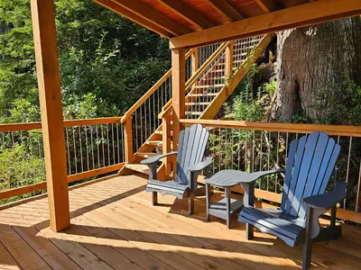 two chairs and a table on a wooden deck at Snug Harbour Inn in Ucluelet