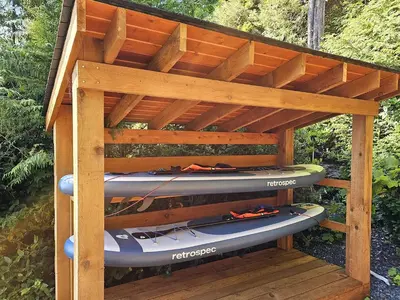 a wooden kayak rack with two kayaks in it at Snug Harbour Inn in Ucluelet