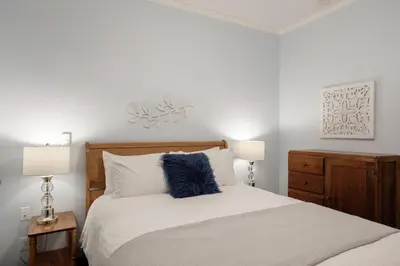 a bedroom with a bed with a blue pillow on it at Bramblebank Cottages in Harrison Hot Springs