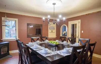 a dining room with a table with chairs and a chandelier at Bramblebank Cottages in Harrison Hot Springs