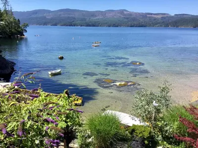 a view of a lake with a boat in the water at The Tuwanek Bed and Breakfast in Sechelt