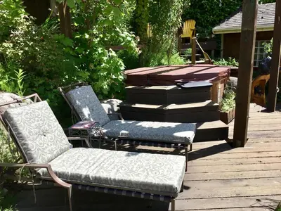 two chairs and a bench on a wooden deck at The Tuwanek Bed and Breakfast in Sechelt