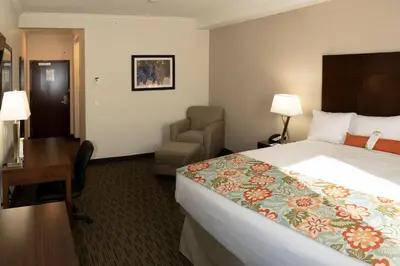 a hotel room with a bed and a chair and a desk at Coast Oliver Hotel in Oliver