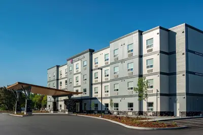 a large white building with a parking lot at Coast Oliver Hotel in Oliver