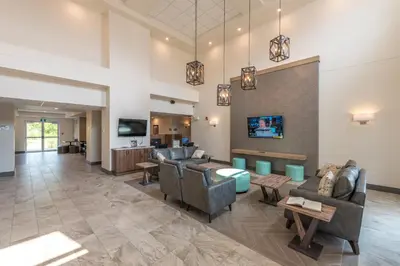 a lobby with couches and chairs and a tv at Coast Oliver Hotel in Oliver