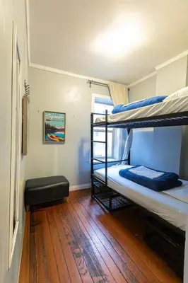 two bunk beds in a room with a wooden floor at The Cambie Hostel Seymour in Vancouver