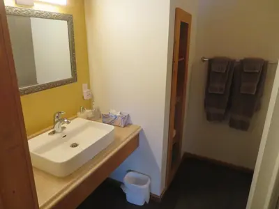 a bathroom with a sink and a mirror and towels at Alpenglow Bed and Breakfast in Kimberley