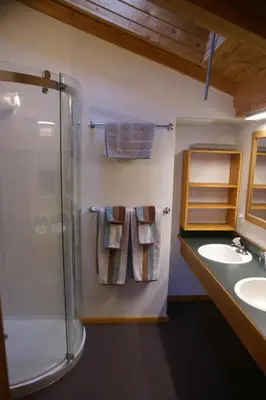 a bathroom with a shower and two sinks and towels at Alpenglow Bed and Breakfast in Kimberley