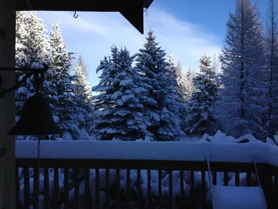 a balcony with snow covered trees and a fence at End of the road B & B in Cranbrook