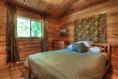 a bedroom with a bed in a log cabin at Heriot Bay Inn in Heriot Bay