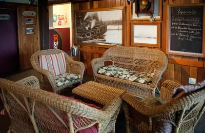 a room with wicker chairs and a chalk board at Heriot Bay Inn in Heriot Bay