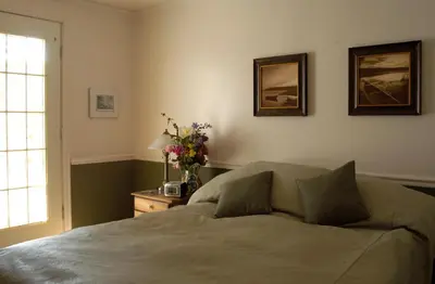 a bedroom with a bed and a table with flowers on it at Heriot Bay Inn in Heriot Bay
