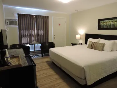 a hotel room with a large bed and a desk at Almo Court Motel in Cranbrook