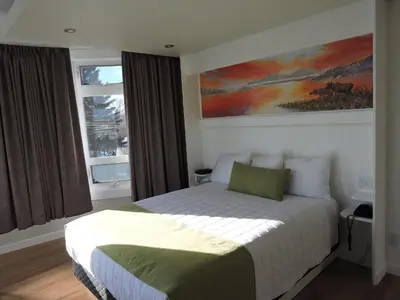 a bedroom with a bed and a painting on the wall at Almo Court Motel in Cranbrook