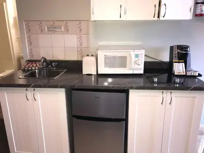 a kitchen counter with a microwave and a sink at Kootenay Country Inn in Cranbrook