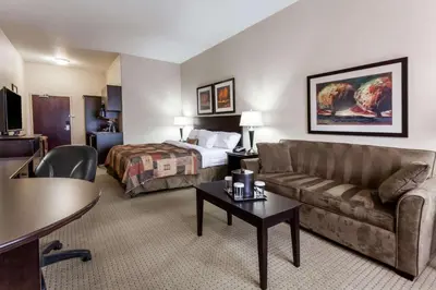 a hotel room with a bed and a couch at Ramada by Wyndham Westlock in Westlock