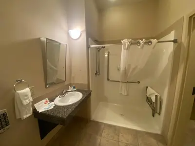 a bathroom with a sink and a shower and a tub at Ramada by Wyndham Westlock in Westlock