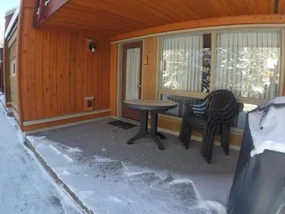a table and a chair on the porch of a cabin at Panorama Vacation Retreat at Horsethief Lodge in Panorama