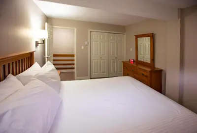 a bedroom with a large white bed and a dresser at Panorama Vacation Retreat at Horsethief Lodge in Panorama