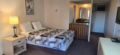 a small bedroom with a bed and a window at Slumber Lodge Williams Lake in Williams Lake