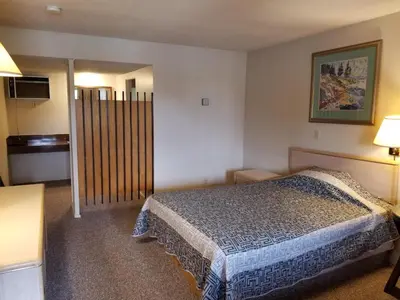 a hotel room with a bed and a television at Slumber Lodge Williams Lake in Williams Lake