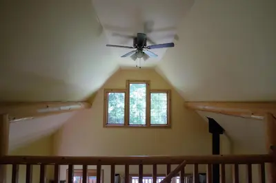 a room with a ceiling fan and a window at Wedgwood Manor and Glamping Retreat in Crawford Bay